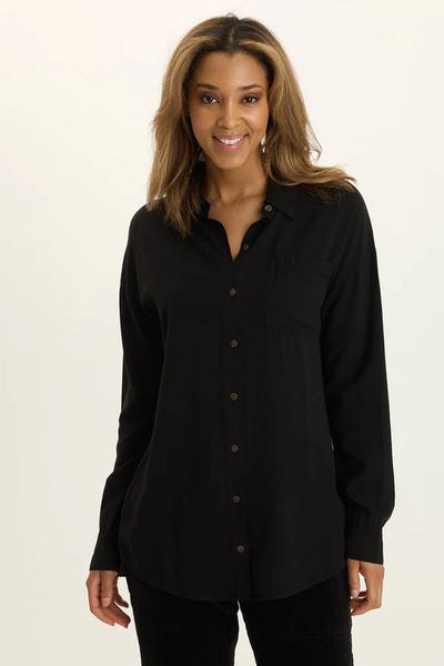 Woman wearing a black button-up shirt against a plain background